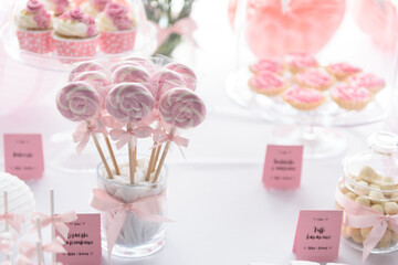 Twisted lollipops and other sweets on a candy bar at the wedding party