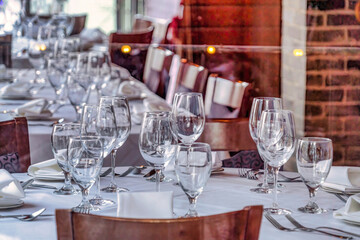 Restaurant interior with wine glasses and tableware and utensils on tables