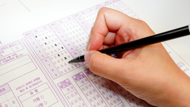 Exam paper, answer sheet with black marker pen. Optional question method test, education system concept, close layout with copy space (Translation: Question, Answer, Type)