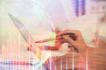 Multi exposure of woman hands typing on computer and financial graph hologram drawing. Stock market analysis concept.