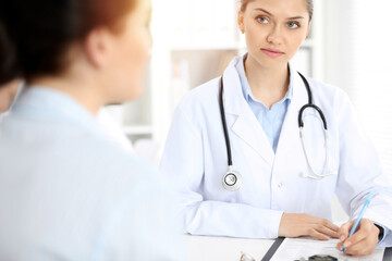 Fototapeta premium Doctor and patient are communicating while sitting at the table