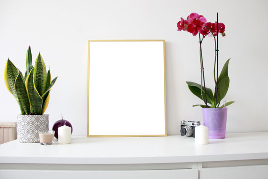empty vertical golden  mockup frame with flowers and candles on the table
