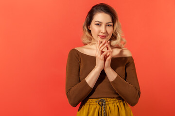 Portrait of sneaky scheming young woman in brown blouse thinking devious plan with cunning face...