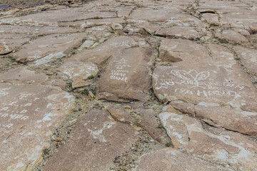 WAKHAN VALLEY, TAJIKISTAN - MAY 23, 2018: Ancient petroglyphs and modern grafitti in Langar village in Wakhan valley, Tajikistan