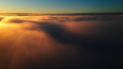 Fototapeta na wymiar Flight above the clouds into a golden sunset.