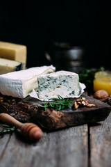 Cheese on a wooden table. Brie, dor blue, parmesan, gouda