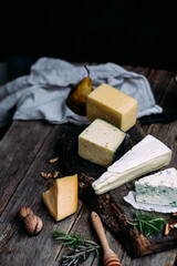 Cheese on a wooden table. Brie, dor blue, parmesan, gouda