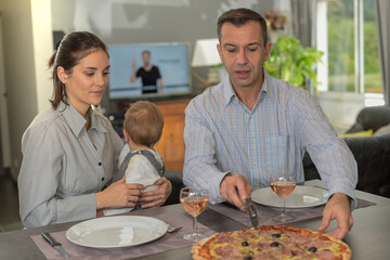 Italian family ready to share  a pizza with their child