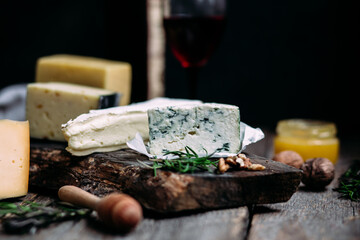 Cheese on a wooden table. Brie, dor blue, parmesan, gouda