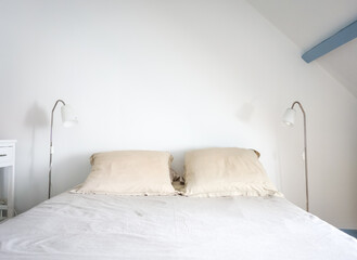 Bed and lamp in a white bedroom
