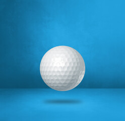 White golf ball on a blue studio background