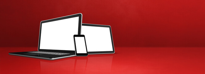 Laptop, mobile phone and digital tablet pc on red office desk. Banner background