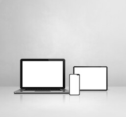 Laptop, mobile phone and digital tablet pc on white concrete office desk