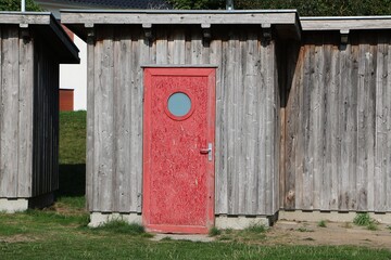 small wooden garden house with a red door