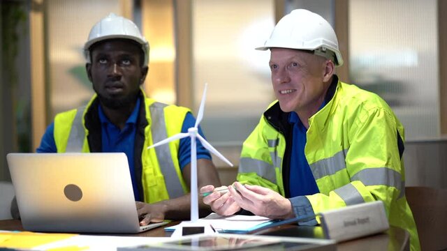 African american technician and senior engineer manager discussion and analyze wind turbines system to energy renewable with windmills models   . team Repair and maintenance