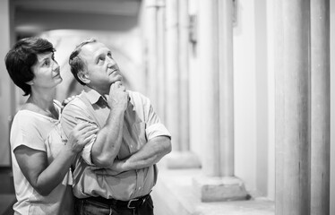 mature couple turists examines the exhibit in  museum