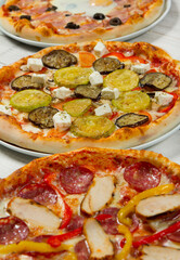 Different slices of pizza with different toppings on a white background. Cut into slices delicious fresh pizza. Tasty pizza on white.