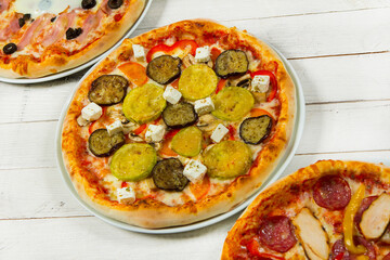 Different slices of pizza with different toppings on a white background. Cut into slices delicious fresh pizza. Tasty pizza on white.