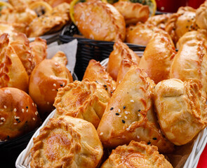 different types of small pies in a basket on a dark background. Bakery products. Catering. Delivery