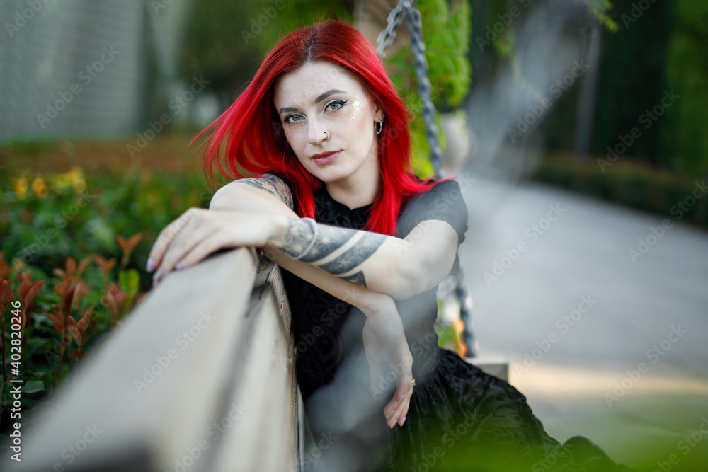 Wall mural red haired girl in dress walks in park