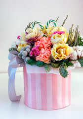 Beautiful winter floral composition with tulips, carnations, cotton flower, spruce branches in box.