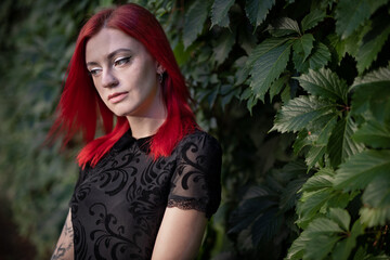 red haired girl in dress walks in park