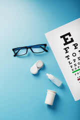 Ophthalmic Accessories Glasses and lenses with an Eye Test Chart for vision correction on a blue...