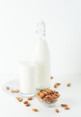 A glass with almond milk and the bowl with almonds
