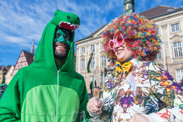Karneval Party Paar mit Sekt Gläsern feiern Fasching draußen.
