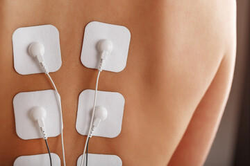 Myostimulation procedure on the back in a beauty salon.