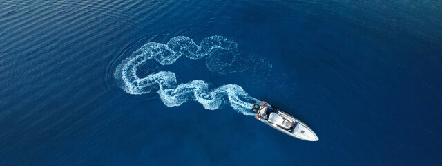 Aerial drone top down ultra wide photo of inflatable power rib boat making extreme manoeuvres in...
