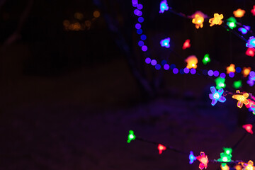 multicolored garland on the tree. .Natural snow background. Concept, winter, new year, christmas