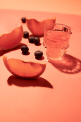 pink shot glass with grapefruit on a pink background