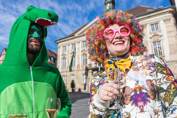 Karneval Party Paar mit Sekt Gläsern feiern Fasching draußen.