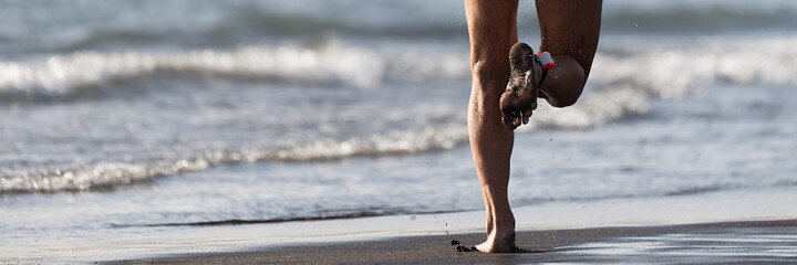 Triathlete running into the sea on the beach