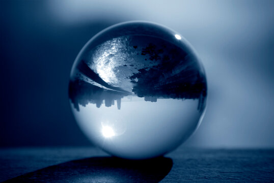 Glass ball with inverted street view. Lens ball photography.