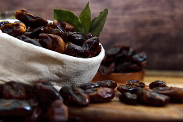 Dry Dates in a rustic sack on a wooden board