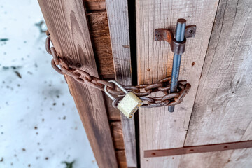 Chained outdoor wooden bathroom door with long shackle combination padlock