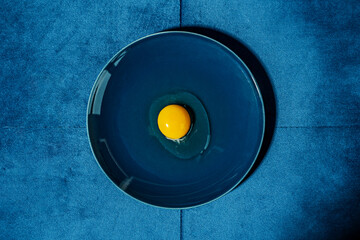 Obraz premium raw egg on blue plate