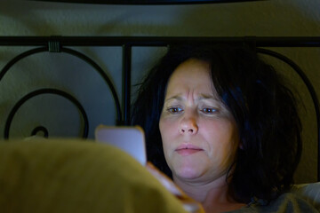 Puzzled Hispanic woman reading a text message