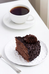 Chocolate cake and coffee, still life in a light interior.