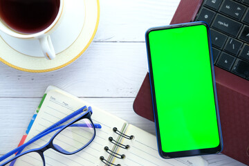 top view of smart phone, laptop and notepad on table 