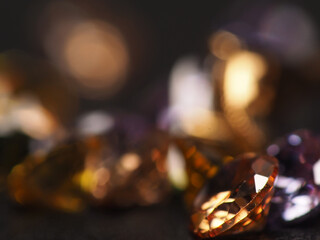 Close up shoot of beautiful, shiny, multi colored diamonds crystal gemstones, shoot on black leather as background