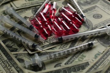 Fototapeta premium Vial with syringe vaccine and many dollars