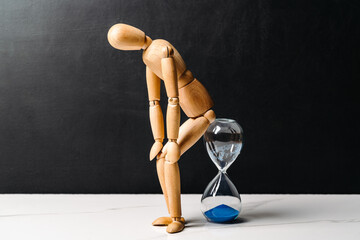 The wooden man sits on the hourglass