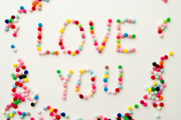 Handmade Valenine pom poms decoration. Written word 