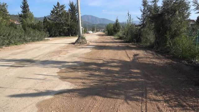 Fethiye, Turkey - 27th of December 2020: 4K Vicinal ground road and an electric pole in the middle
