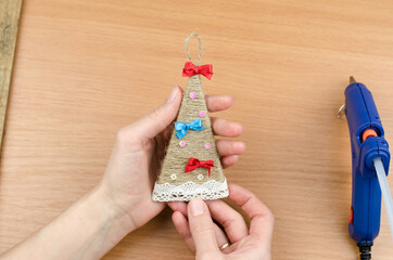 Step by step woman makes a Christmas tree from cardboard and twine. New Year and Christmas handmade