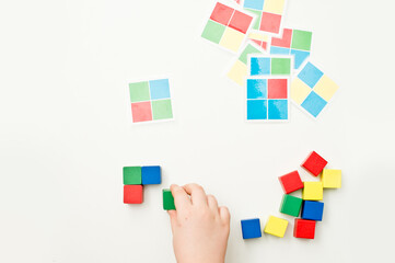 repeat the sequence. color squares on laminated paper. wooden cubes to achieve task