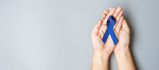 March Colorectal Cancer Awareness month, Man holding dark Blue Ribbon for supporting people living...
